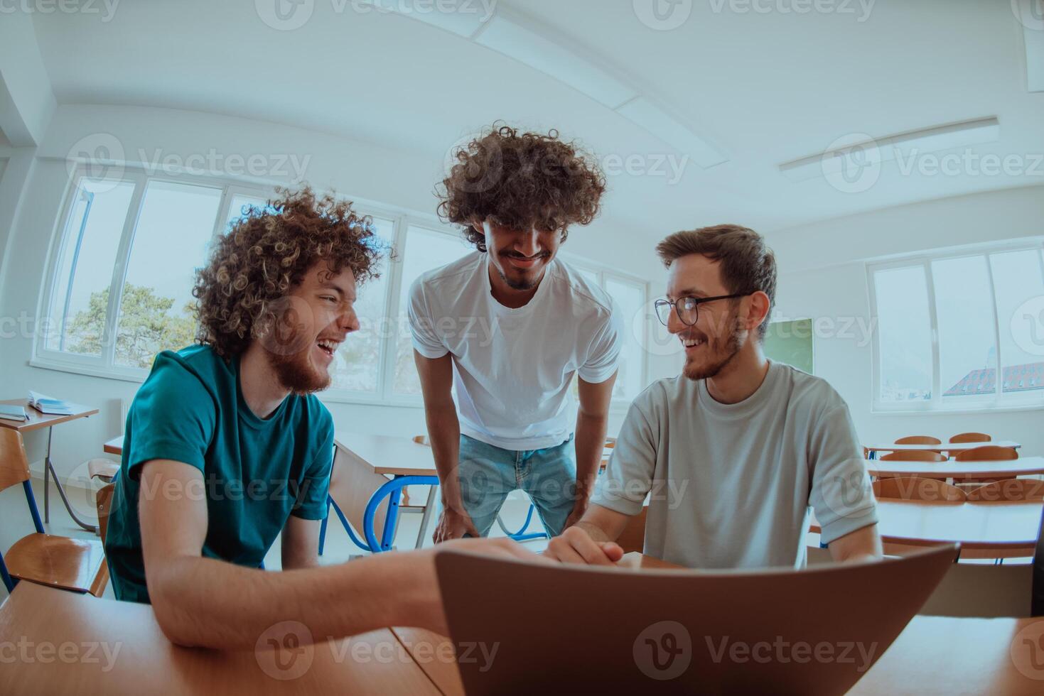 A diverse studetns group, including an Afro American with an afro hairstyle communicating and engage with their colleague while seated in a modern classroom, collectively focused on a laptop. photo