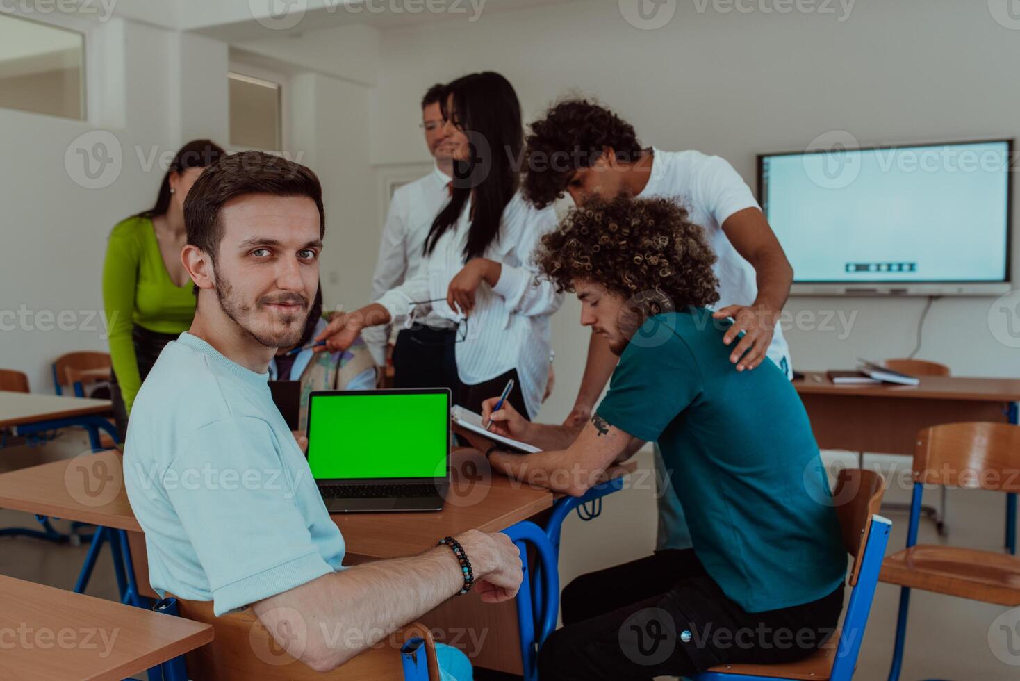A group of business colleagues exchange knowledge and insights while utilizing laptops in the office, showcasing collaborative learning, effective communication, and a dynamic corporate environment photo