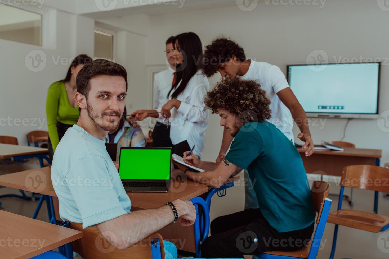 A group of business colleagues exchange knowledge and insights while utilizing laptops in the office, showcasing collaborative learning, effective communication, and a dynamic corporate environment photo