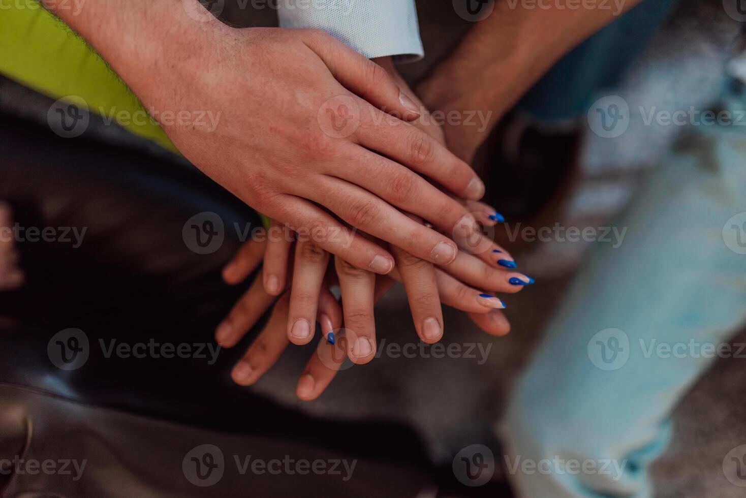 A diverse group of students symbolizes unity as they interlace their hands, portraying a sense of community, collaboration, and inclusive harmony photo