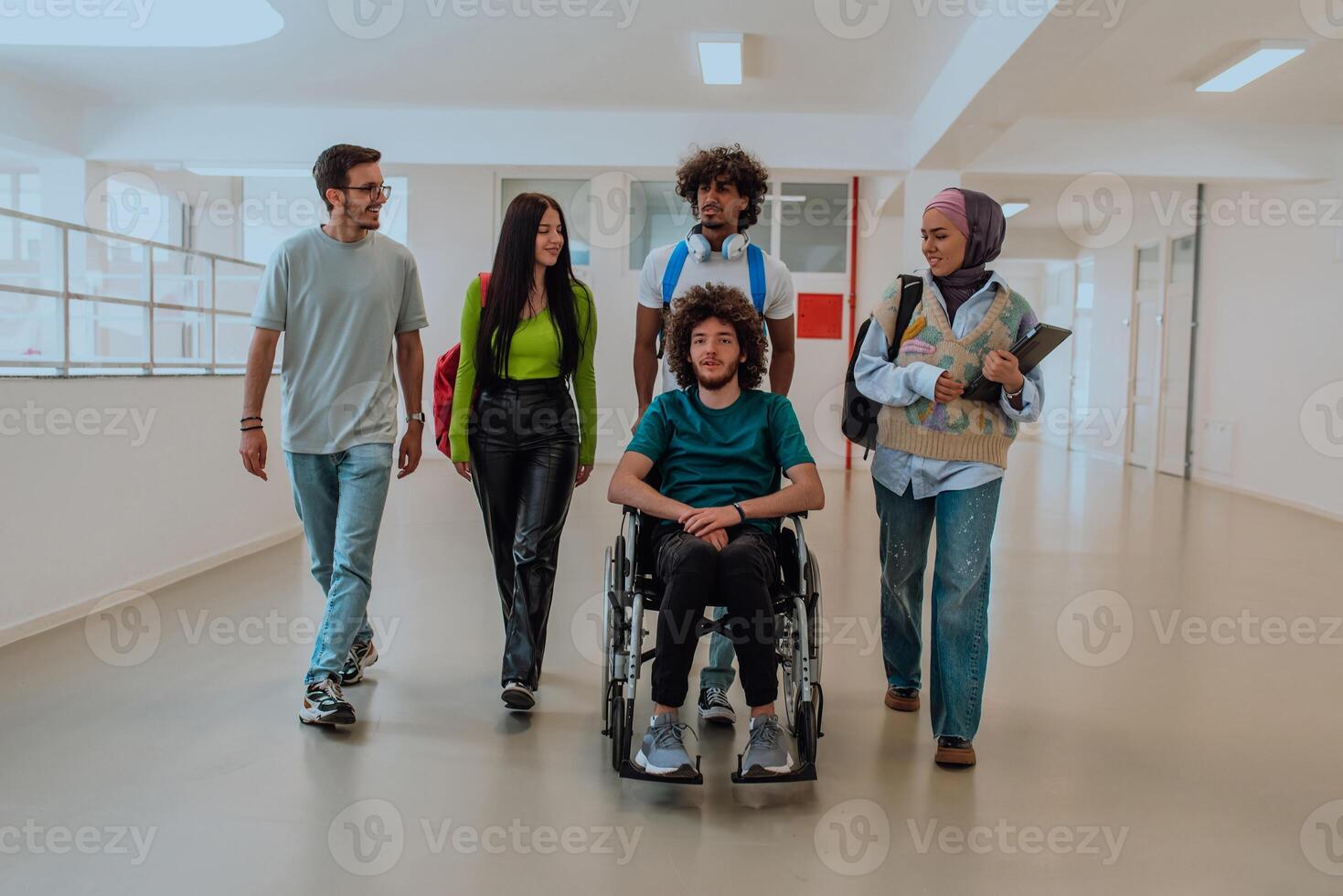 In a modern university, a diverse group of students, including an African-American student and a hijab-wearing woman, walking together in the hallway, accompanied by their wheelchair-bound colleague. photo