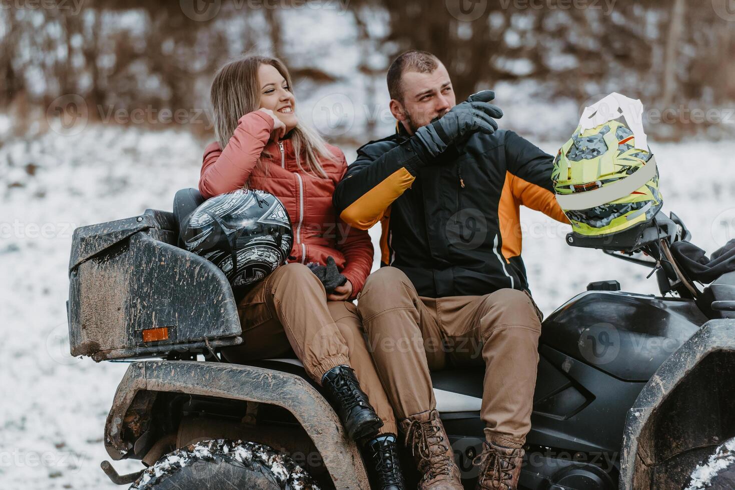 A young adventurous couple embraces the joy of love and thrill as they ride an ATV Quad through the snowy mountainous terrain photo