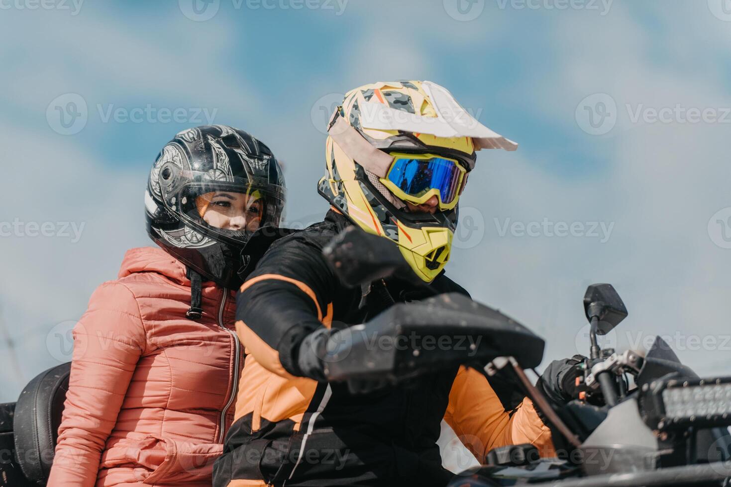 A young adventurous couple embraces the joy of love and thrill as they ride an ATV Quad through the snowy mountainous terrain photo