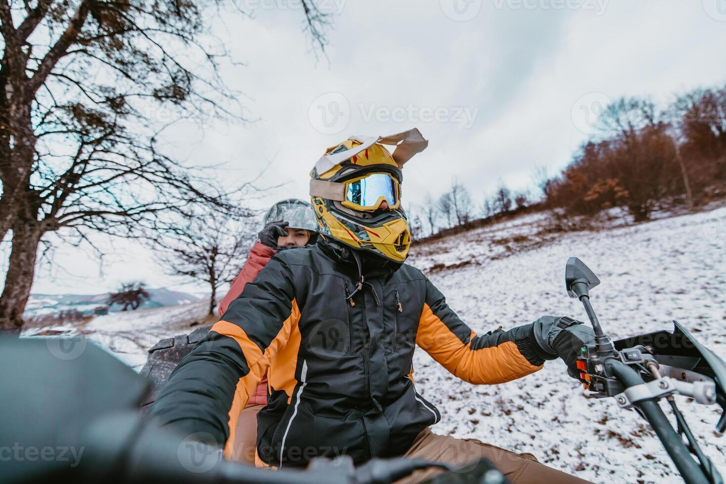 A young adventurous couple embraces the joy of love and thrill as they ride an ATV Quad through the snowy mountainous terrain photo