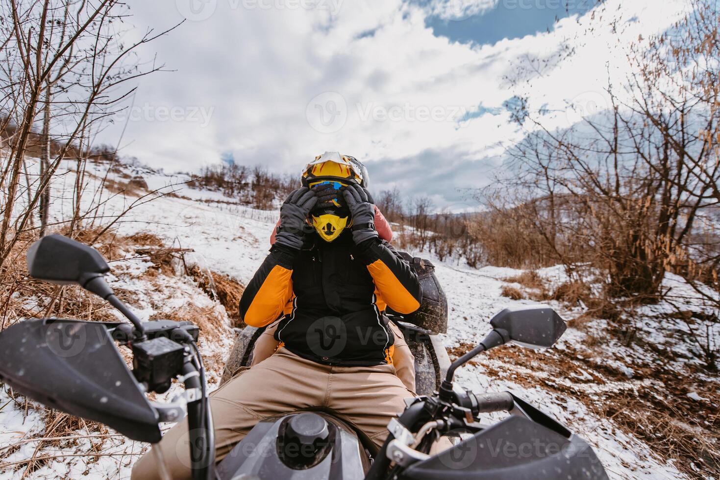 A young adventurous couple embraces the joy of love and thrill as they ride an ATV Quad through the snowy mountainous terrain photo