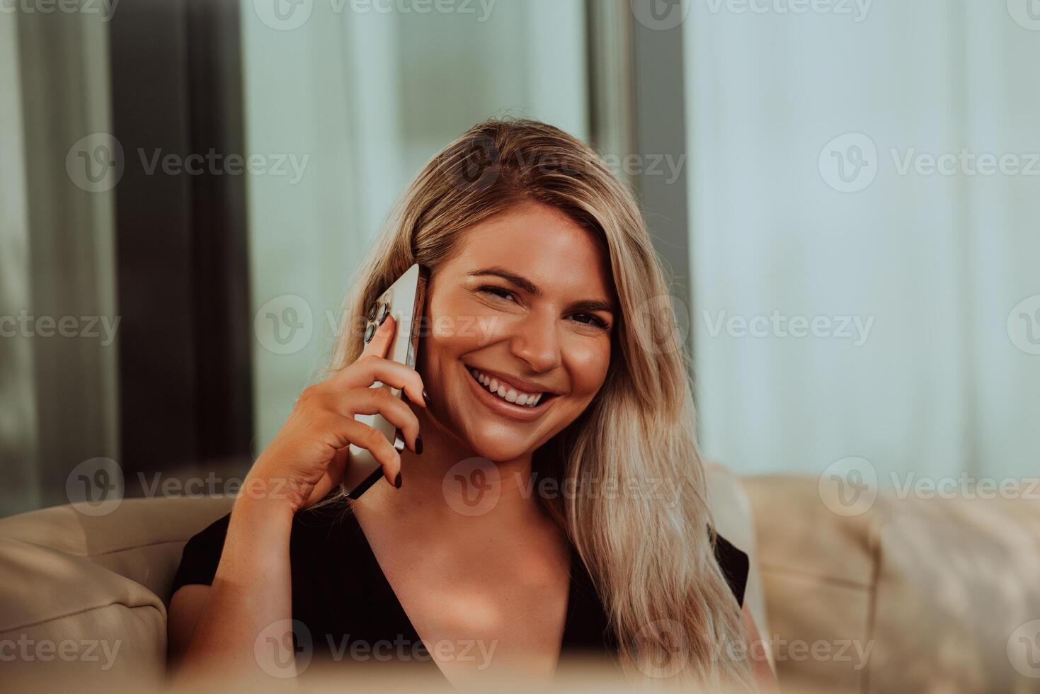 A modern and confident businesswoman, with a cheerful smile, engages in a successful phone conversation, indicating the accomplishment of a new business project. photo