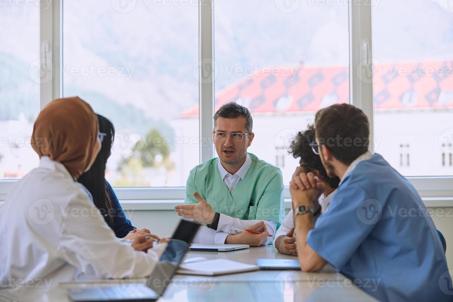 A dedicated group of doctors and medical nurses attentively listens to their colleague's work plan in a healthcare facility, fostering collaboration and ensuring high-quality patient care photo