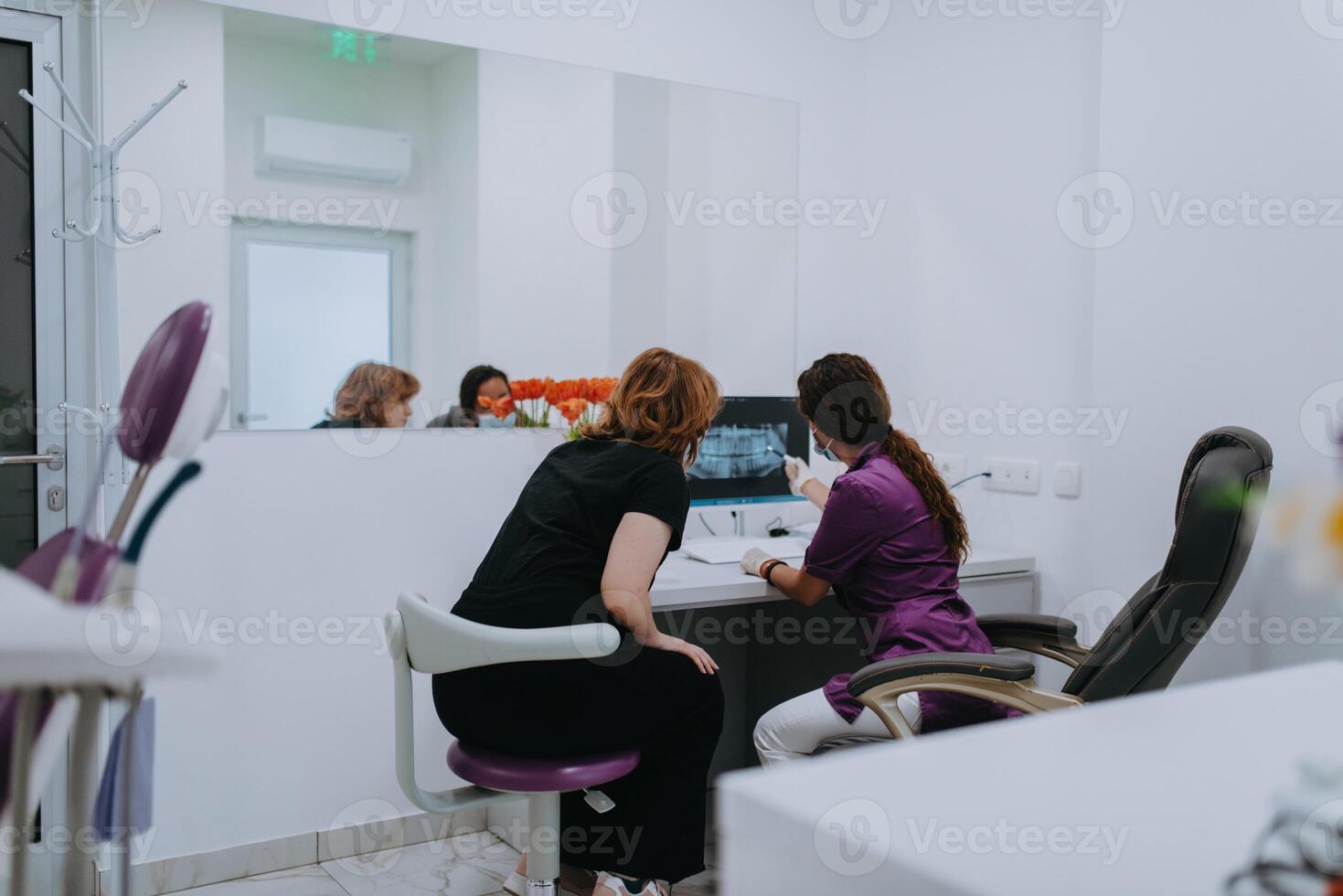 In a modern dental office, a dentist and a young patient engage in a collaborative consultation, exploring new tooth shades and discussing treatment options using a computer photo
