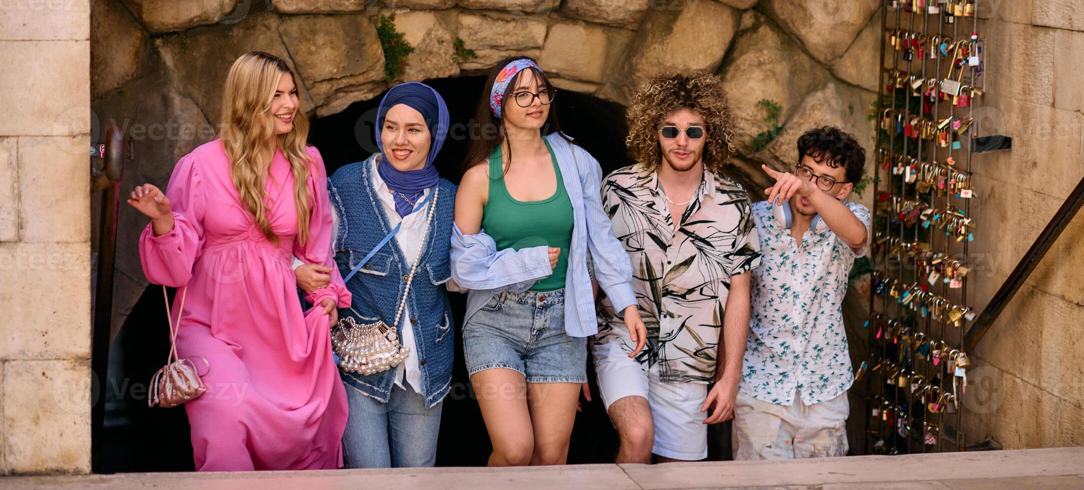 A diverse group of tourists, dressed in summer attire, strolls through the tourist city with wide smiles, enjoying their sightseeing adventure photo
