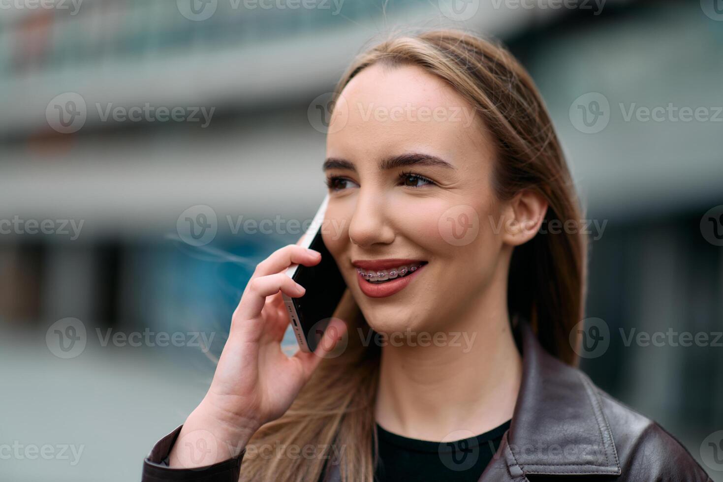 Business Woman With Phone Near Office. Portrait Of Beautiful Smiling Female In Fashion Office Clothes Talking On Phone While Standing Outdoors. Phone Communication. photo