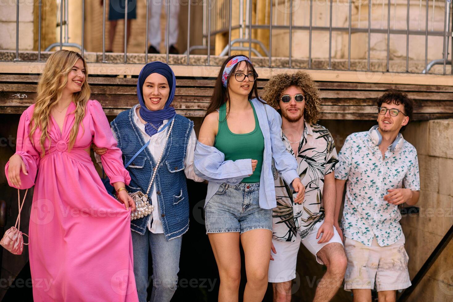 A diverse group of tourists, dressed in summer attire, strolls through the tourist city with wide smiles, enjoying their sightseeing adventure photo