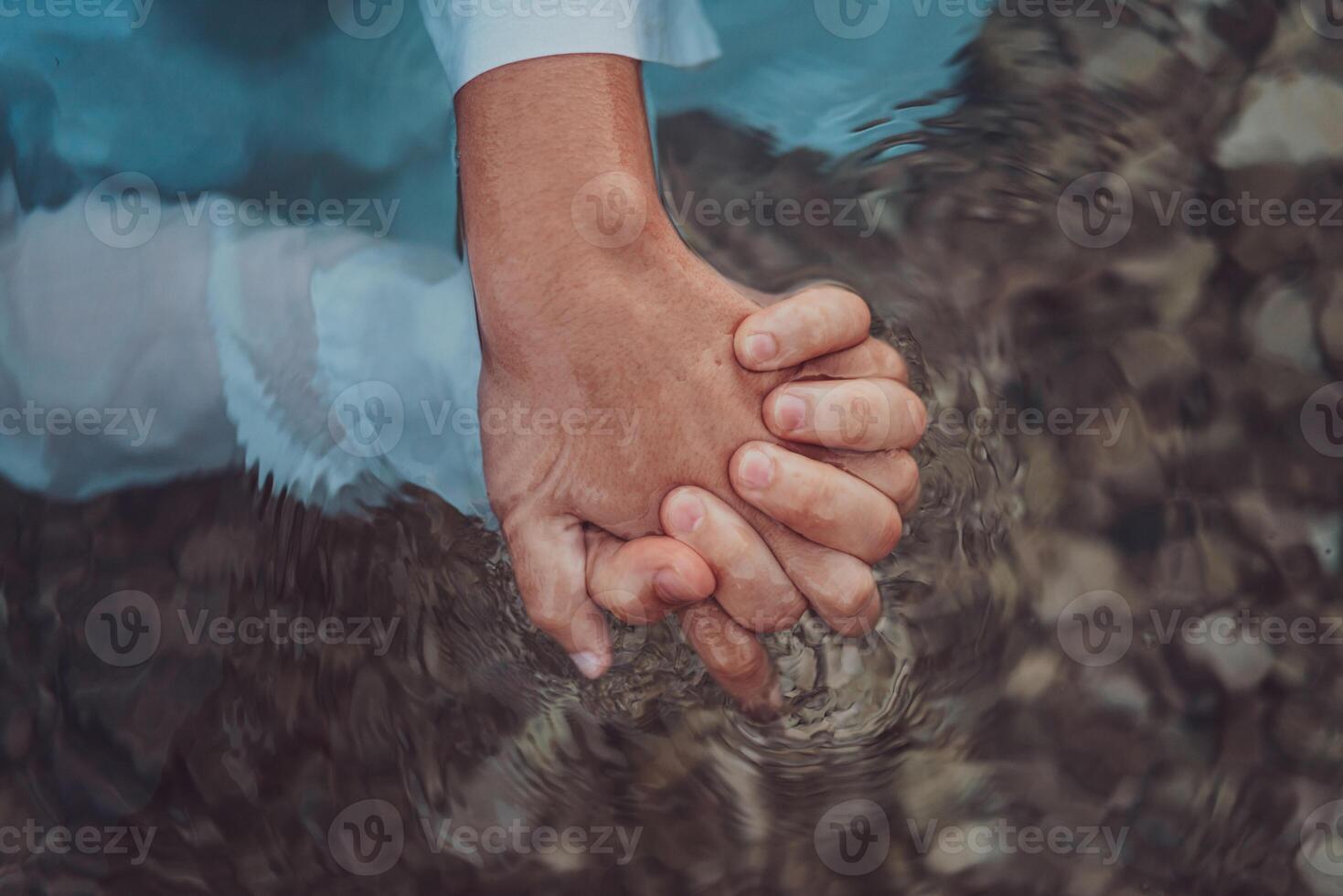 Close up photo the hands of a romantic couple are intimately entwined beneath the water's surface, capturing the tactile and aquatic essence of their love in a sensory embrace