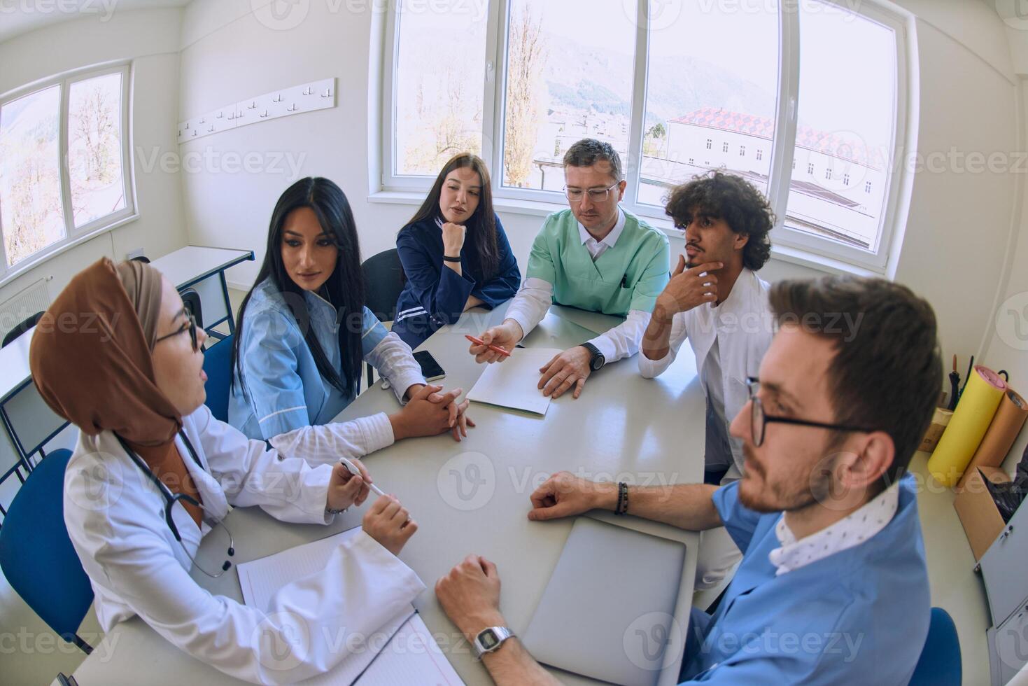 A dedicated group of doctors and medical nurses attentively listens to their colleague's work plan in a healthcare facility, fostering collaboration and ensuring high-quality patient care photo