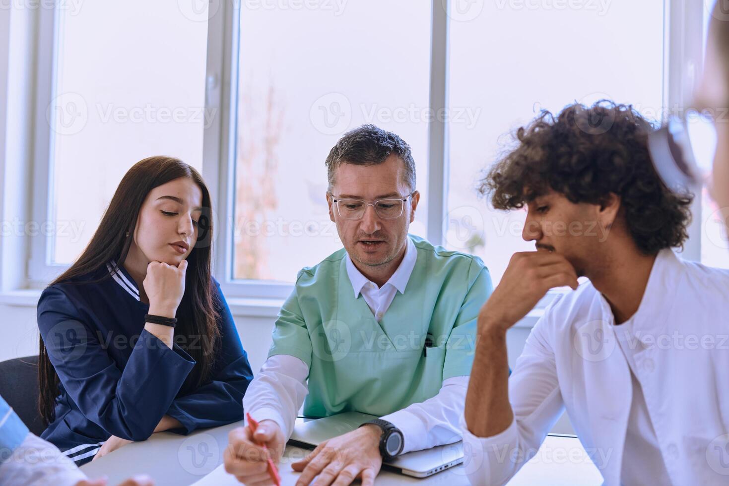 A dedicated group of doctors and medical nurses attentively listens to their colleague's work plan in a healthcare facility, fostering collaboration and ensuring high-quality patient care photo