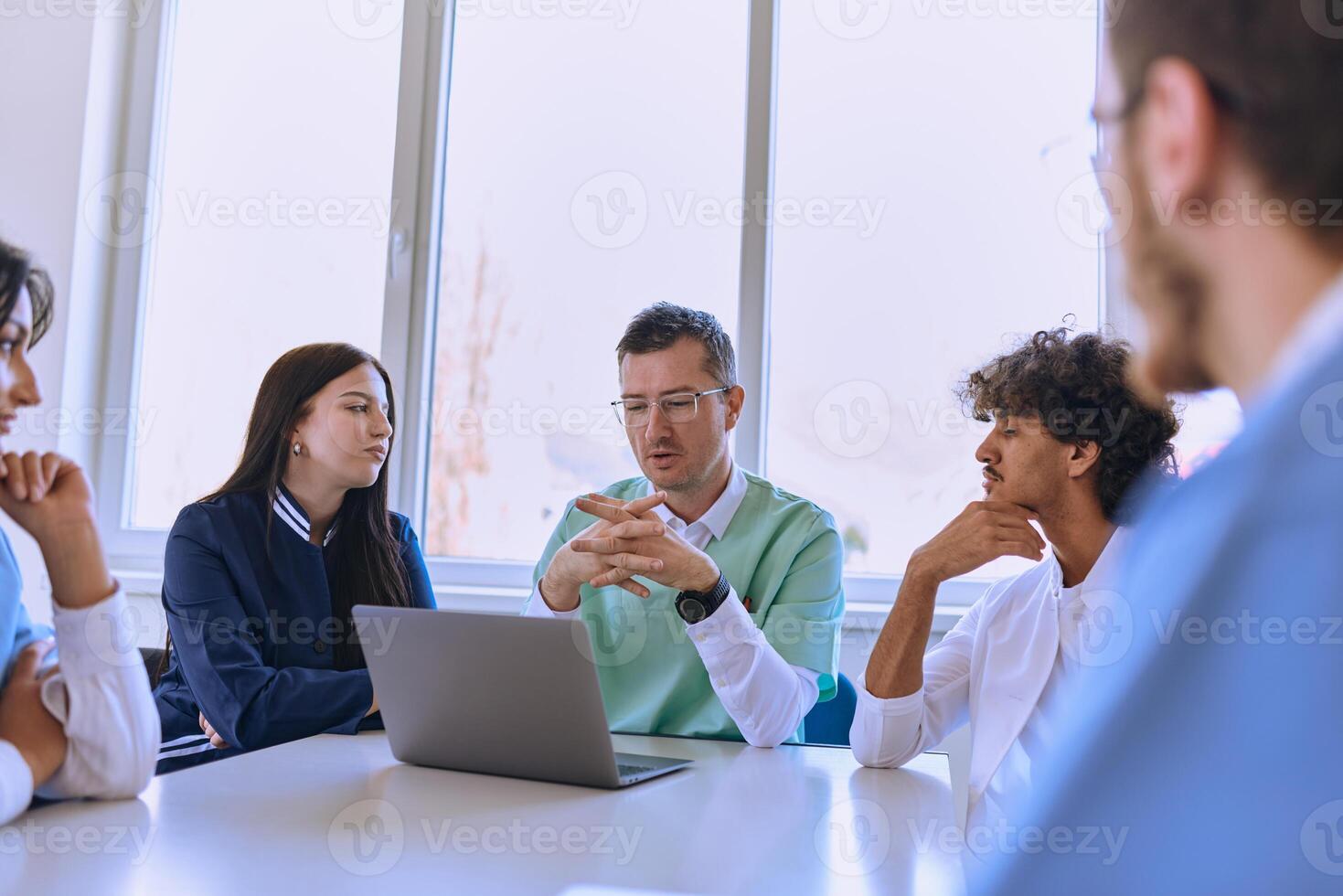 A dedicated group of doctors and medical nurses attentively listens to their colleague's work plan in a healthcare facility, fostering collaboration and ensuring high-quality patient care photo