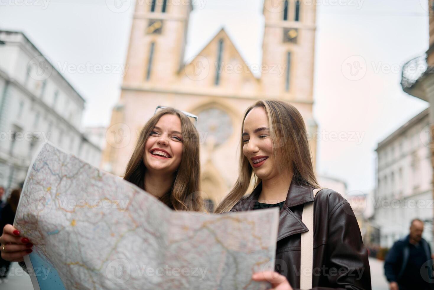 Two female tourists engage in lively discussion, surrounded by their luggage, as they plan their sightseeing journey through the bustling city streets, map in hand. photo