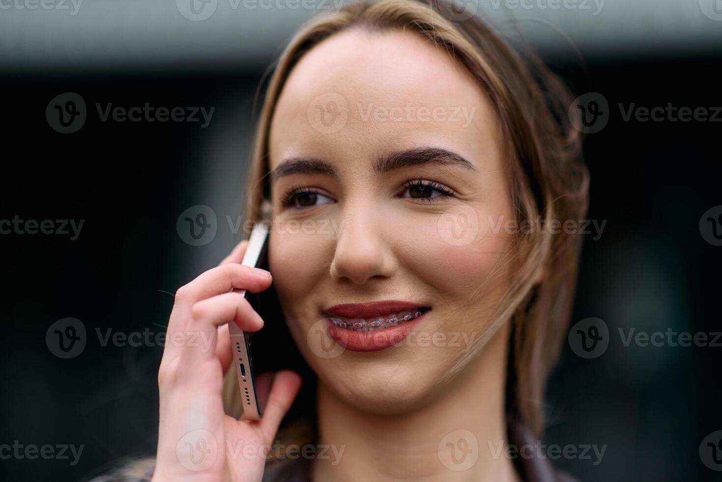 Business Woman With Phone Near Office. Portrait Of Beautiful Smiling Female In Fashion Office Clothes Talking On Phone While Standing Outdoors. Phone Communication. photo
