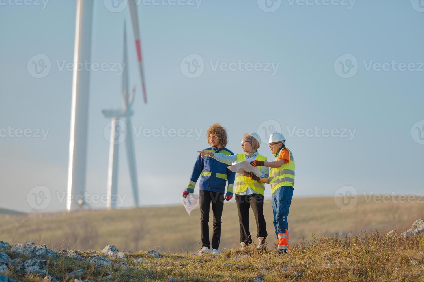A team of engineers and workers oversees a wind turbine project at a modern wind farm, working together to ensure the efficient generation of renewable energy photo