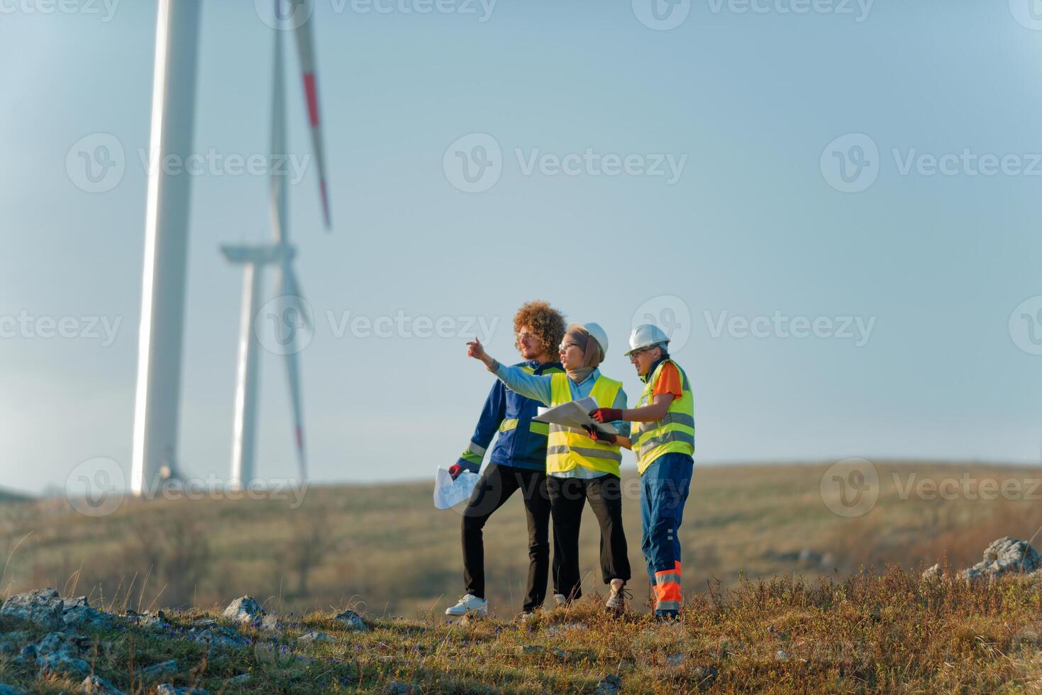 A team of engineers and workers oversees a wind turbine project at a modern wind farm, working together to ensure the efficient generation of renewable energy photo