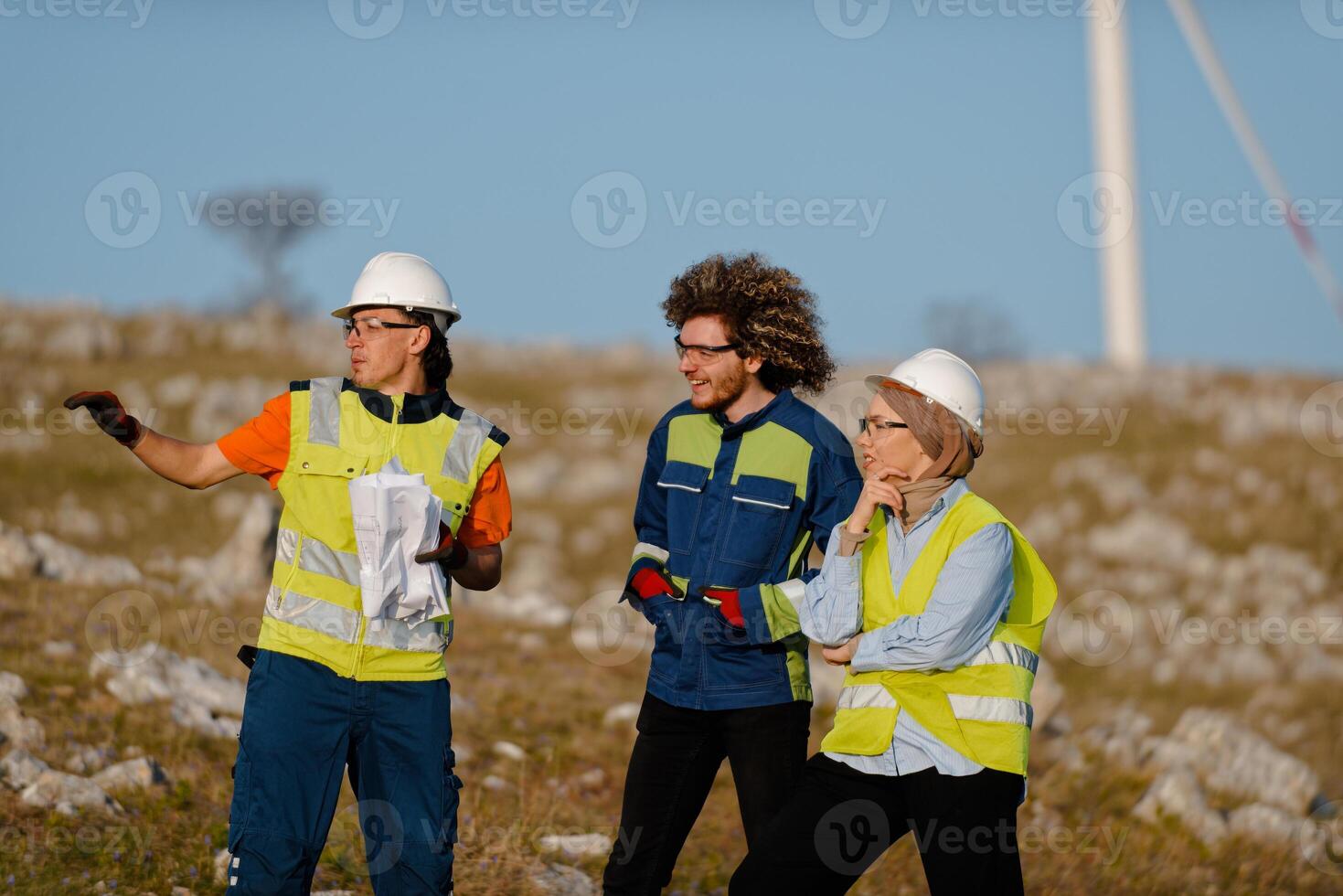 A team of engineers and workers oversees a wind turbine project at a modern wind farm, working together to ensure the efficient generation of renewable energy photo