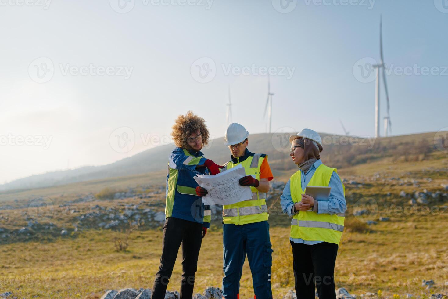 A team of engineers and workers oversees a wind turbine project at a modern wind farm, working together to ensure the efficient generation of renewable energy photo