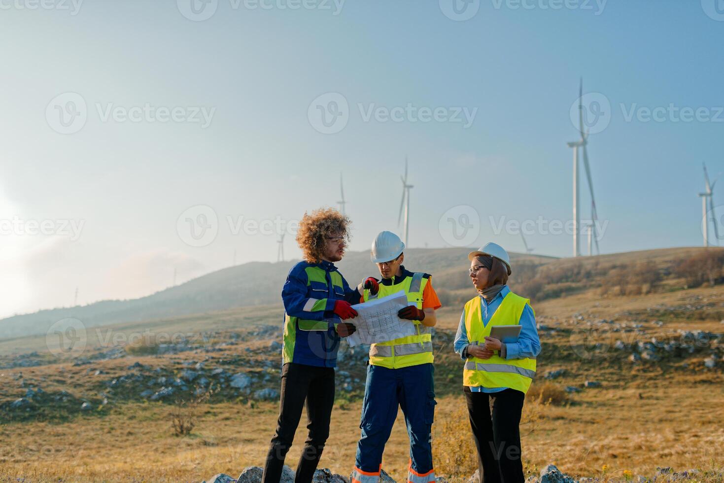 A team of engineers and workers oversees a wind turbine project at a modern wind farm, working together to ensure the efficient generation of renewable energy photo