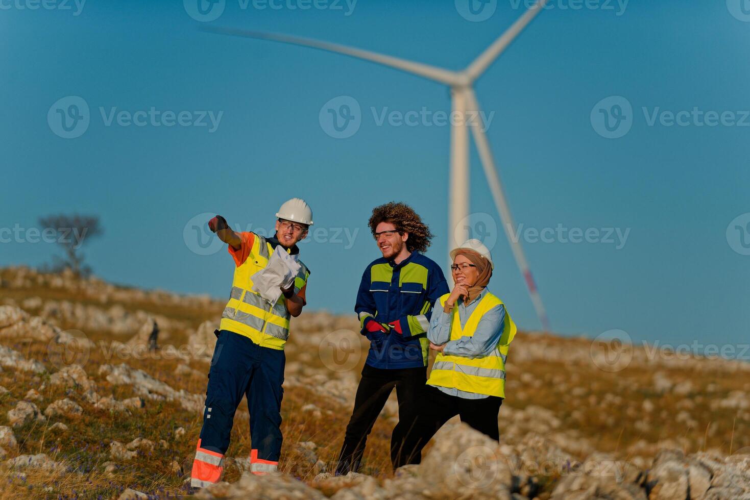 A team of engineers and workers oversees a wind turbine project at a modern wind farm, working together to ensure the efficient generation of renewable energy photo
