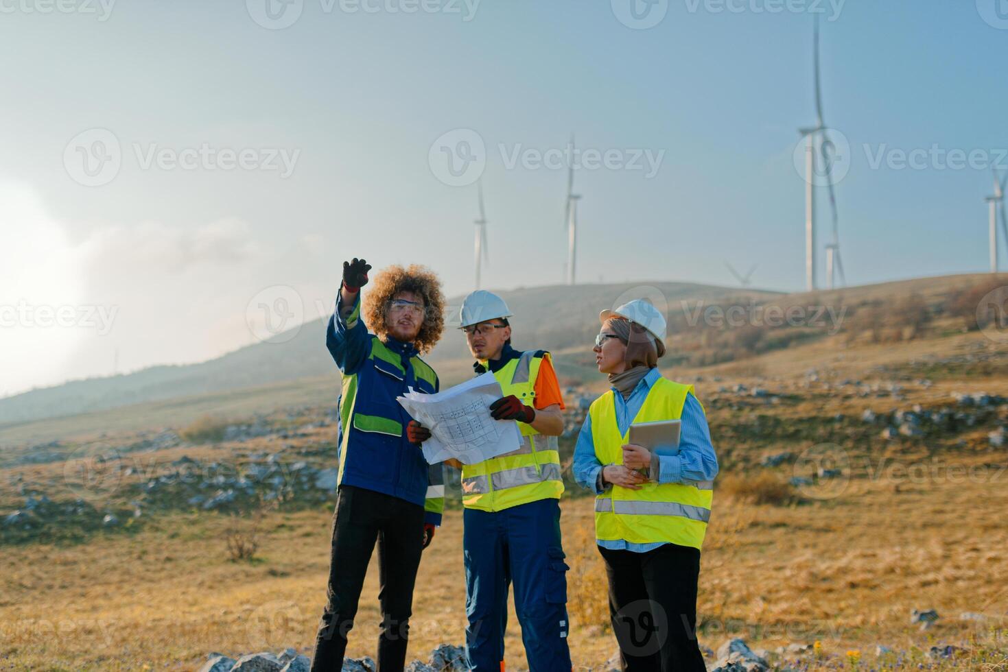 A team of engineers and workers oversees a wind turbine project at a modern wind farm, working together to ensure the efficient generation of renewable energy photo