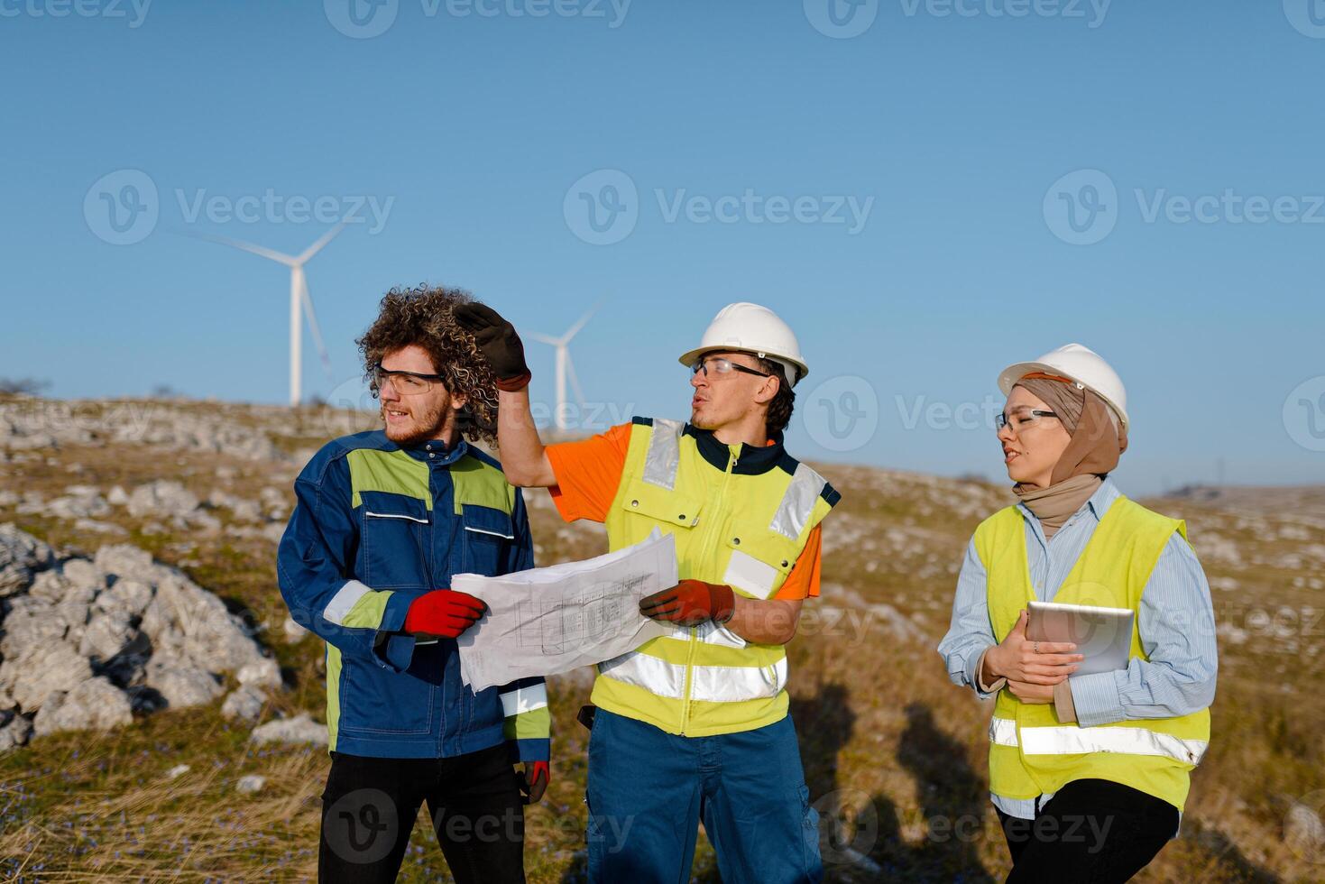 A team of engineers and workers oversees a wind turbine project at a modern wind farm, working together to ensure the efficient generation of renewable energy photo