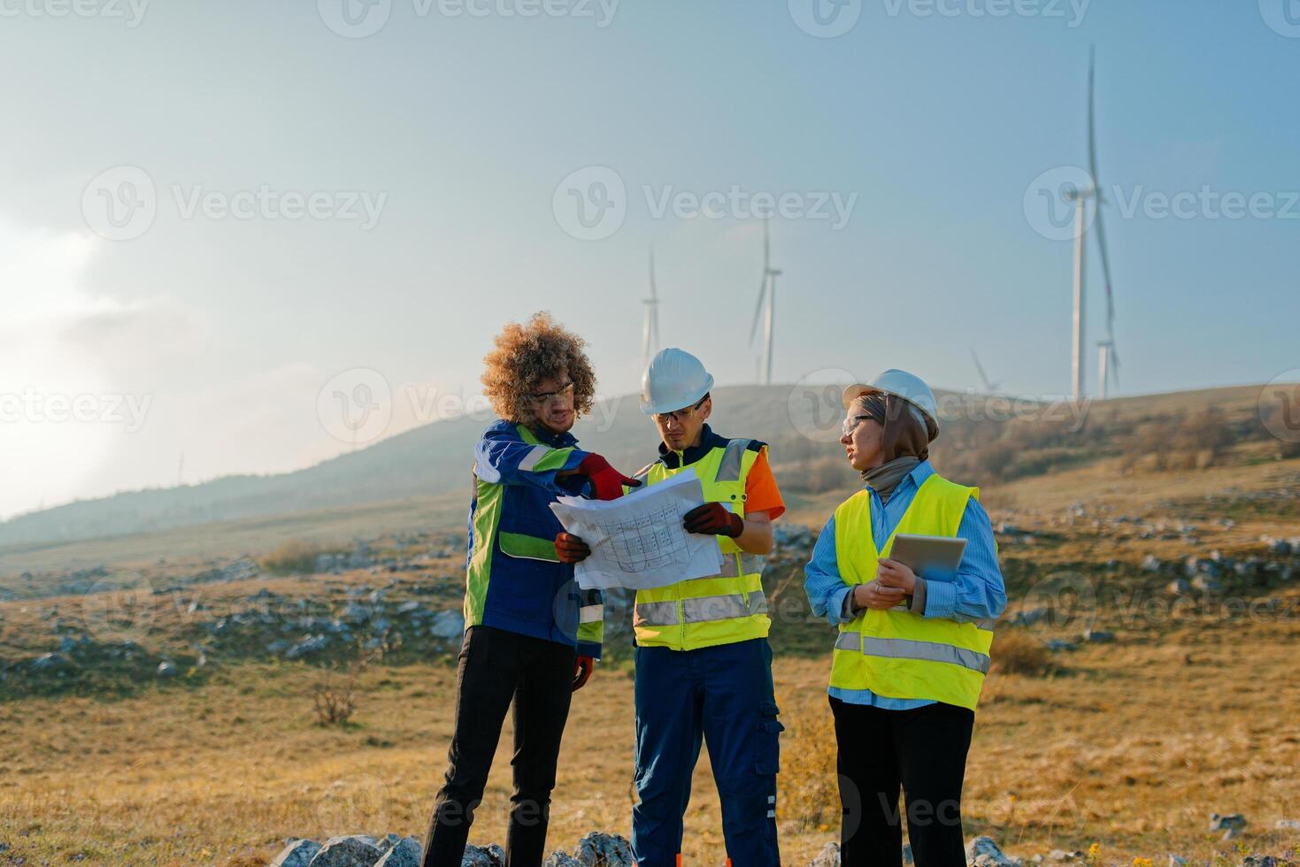 A team of engineers and workers oversees a wind turbine project at a modern wind farm, working together to ensure the efficient generation of renewable energy photo