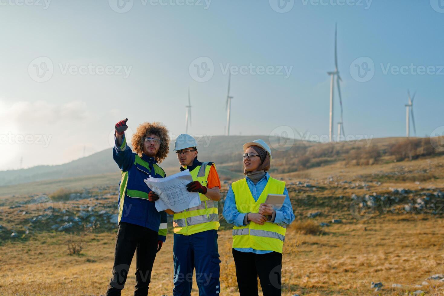 A team of engineers and workers oversees a wind turbine project at a modern wind farm, working together to ensure the efficient generation of renewable energy photo