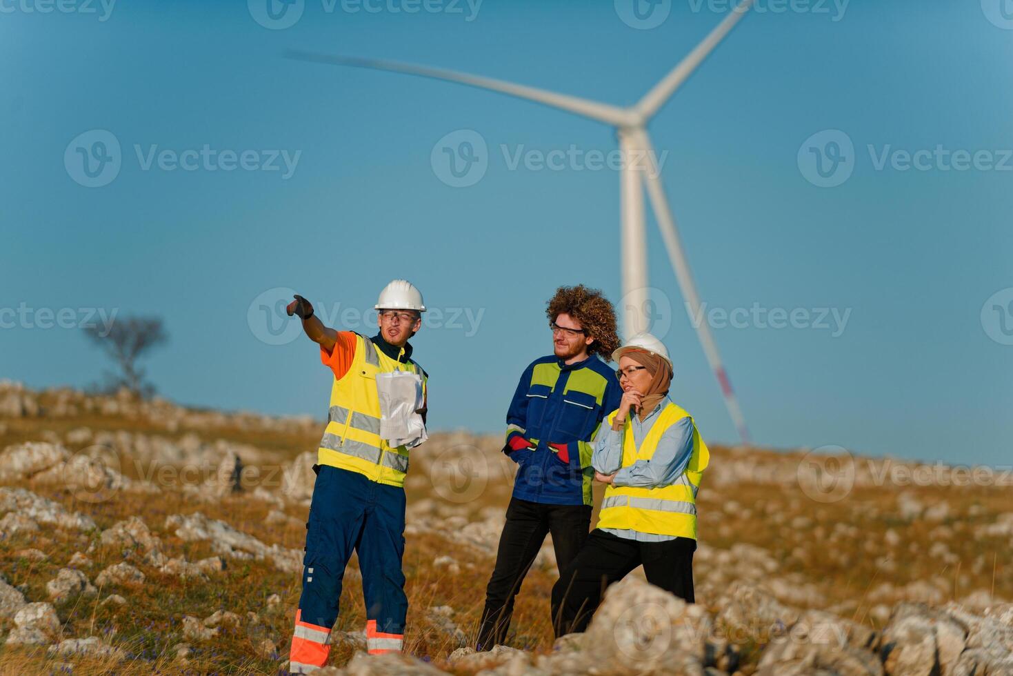A team of engineers and workers oversees a wind turbine project at a modern wind farm, working together to ensure the efficient generation of renewable energy photo