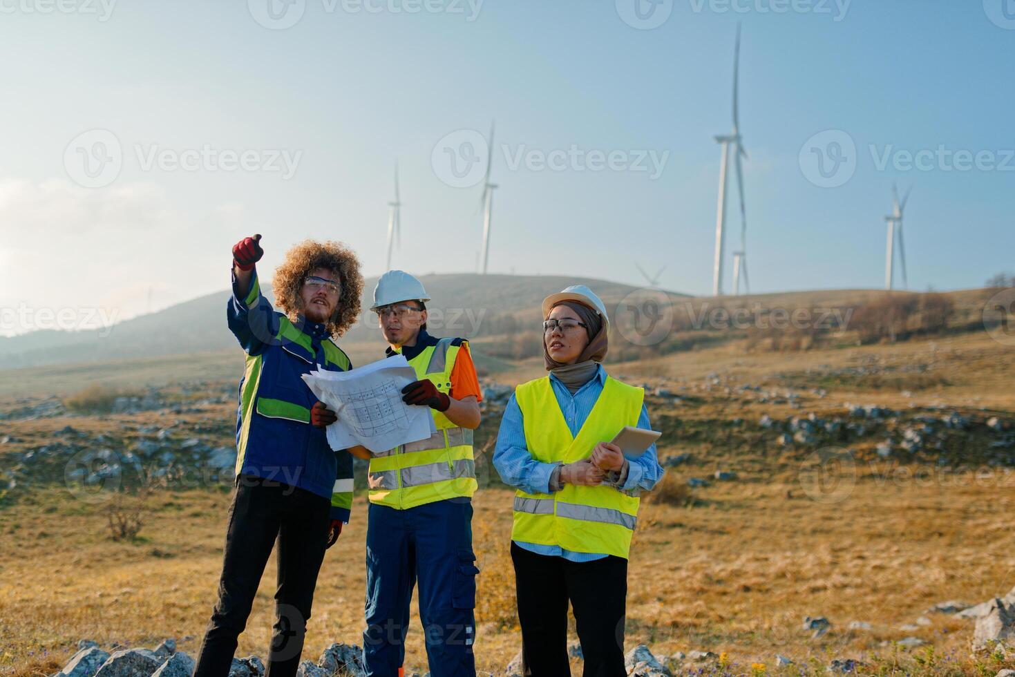 A team of engineers and workers oversees a wind turbine project at a modern wind farm, working together to ensure the efficient generation of renewable energy photo