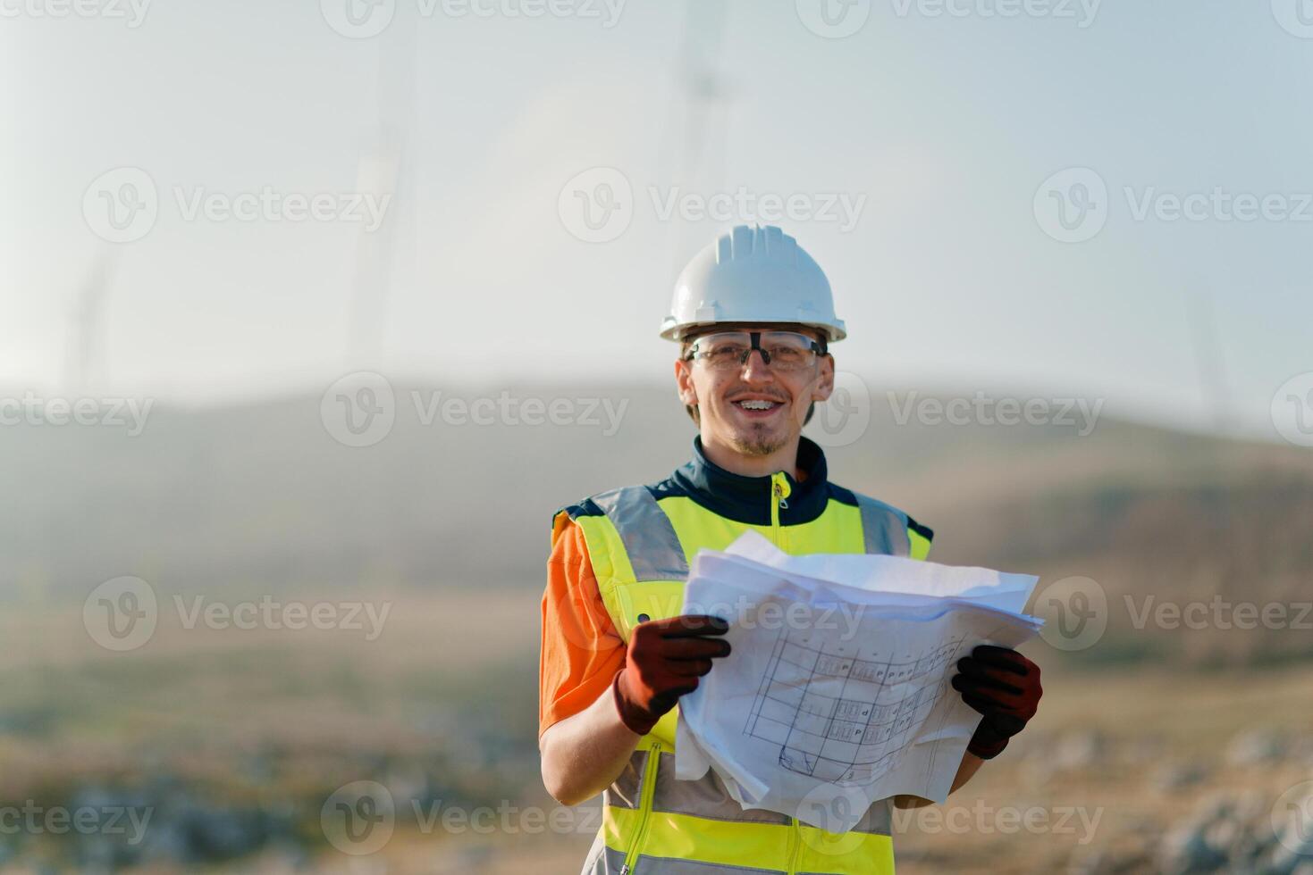 An engineer holding a paper project of a wind turbine for electricity production. photo