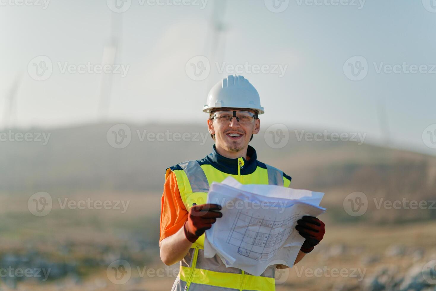 An engineer holding a paper project of a wind turbine for electricity production. photo