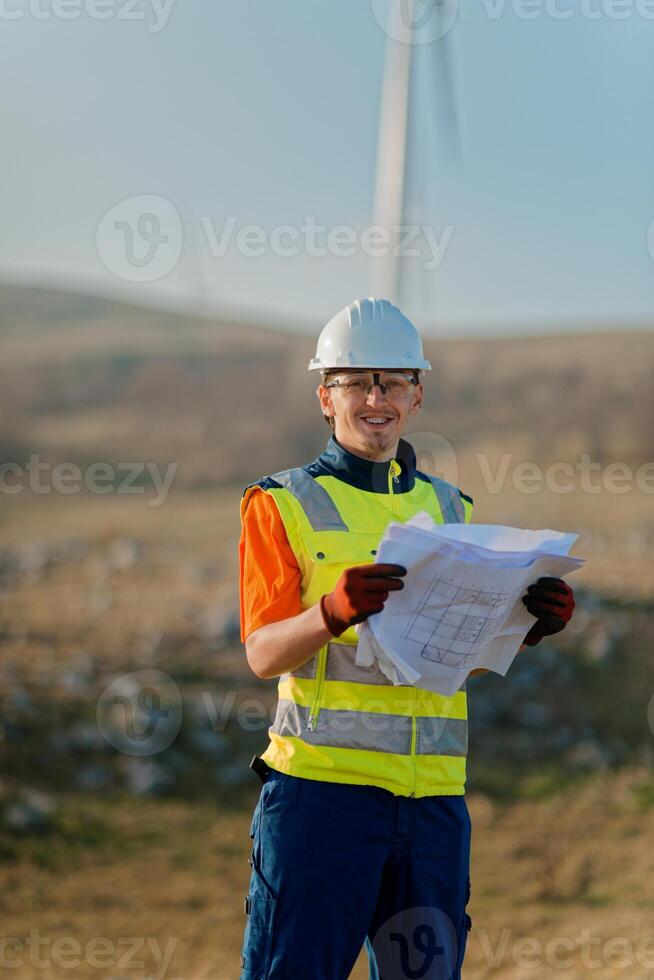 An engineer holding a paper project of a wind turbine for electricity production. photo