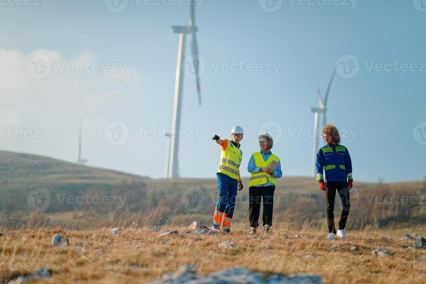 A team of engineers and workers oversees a wind turbine project at a modern wind farm, working together to ensure the efficient generation of renewable energy photo