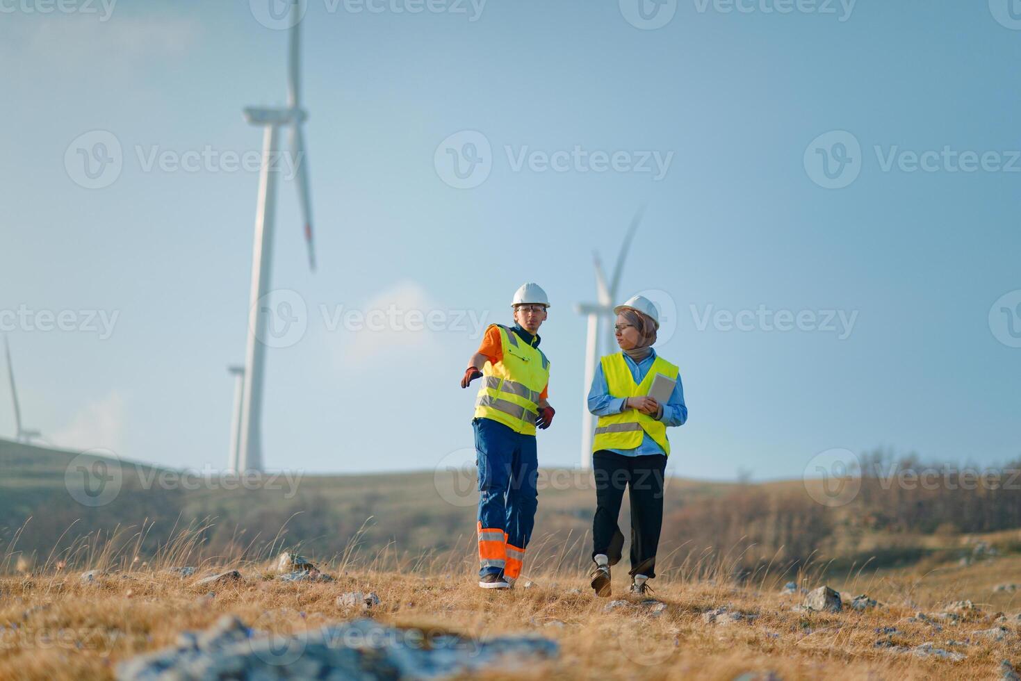 A team of engineers and workers oversees a wind turbine project at a modern wind farm, working together to ensure the efficient generation of renewable energy photo