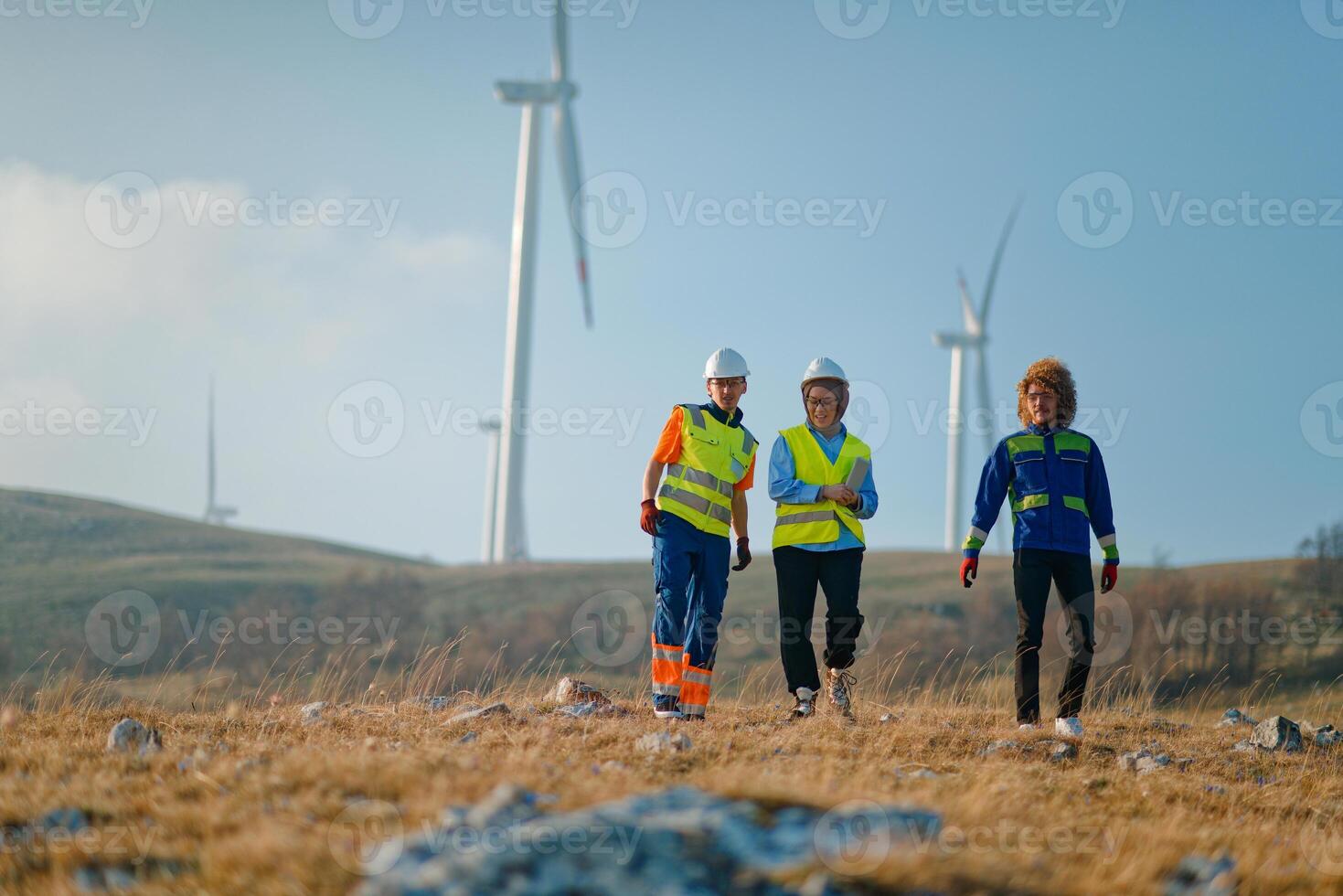 A team of engineers and workers oversees a wind turbine project at a modern wind farm, working together to ensure the efficient generation of renewable energy photo