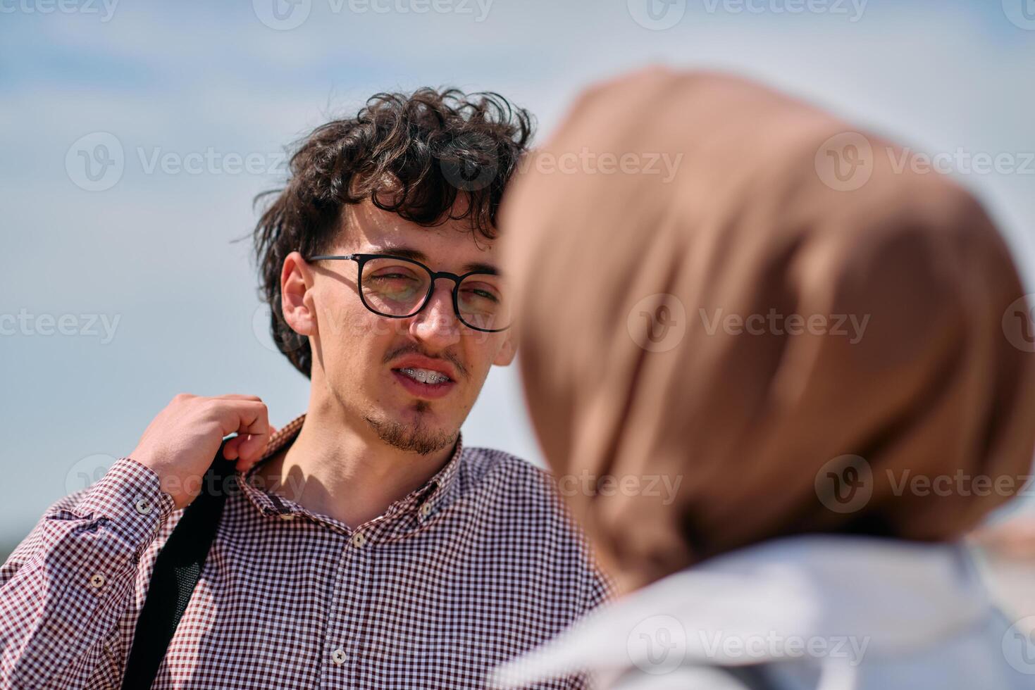 After a day at the office, a business man engages in conversation with his Muslim colleague wearing a hijab photo