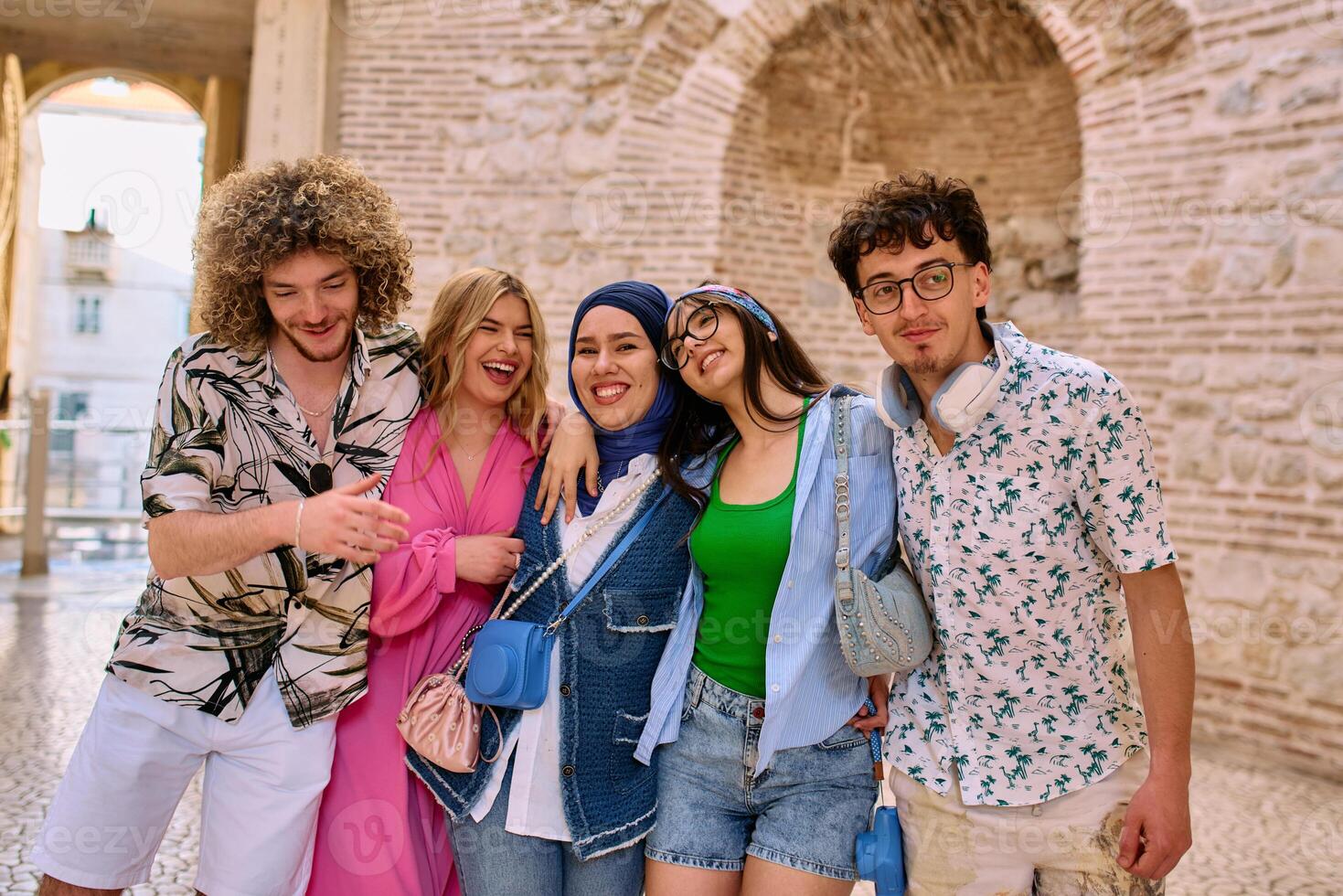A diverse group of tourists, dressed in summer attire, strolls through the tourist city with wide smiles, enjoying their sightseeing adventure photo
