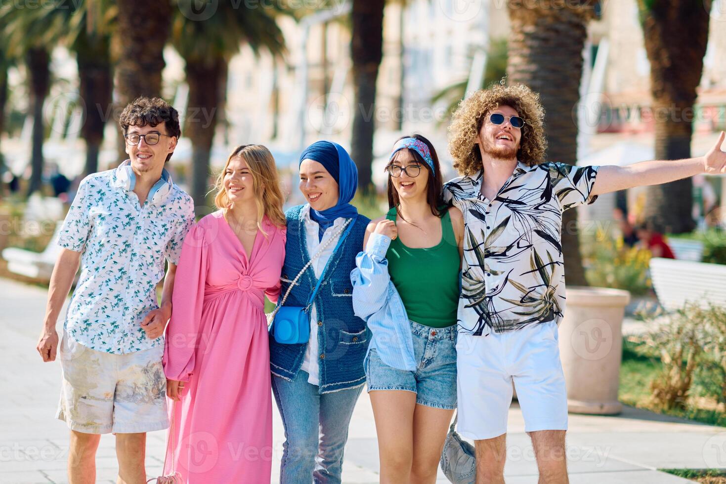 A diverse group of tourists, dressed in summer attire, strolls through the tourist city with wide smiles, enjoying their sightseeing adventure photo