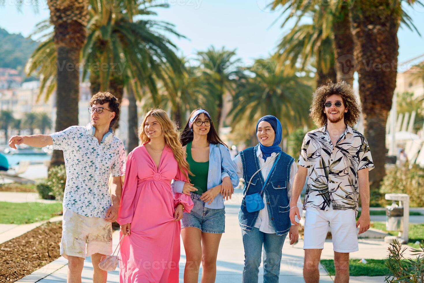 A diverse group of tourists, dressed in summer attire, strolls through the tourist city with wide smiles, enjoying their sightseeing adventure photo