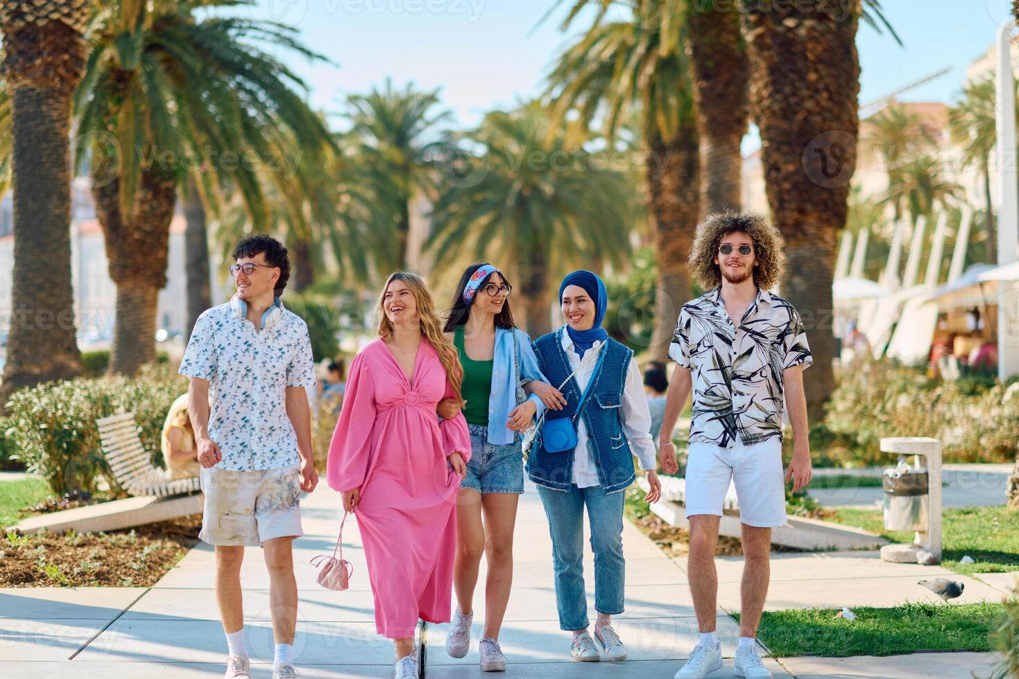 A diverse group of tourists, dressed in summer attire, strolls through the tourist city with wide smiles, enjoying their sightseeing adventure photo