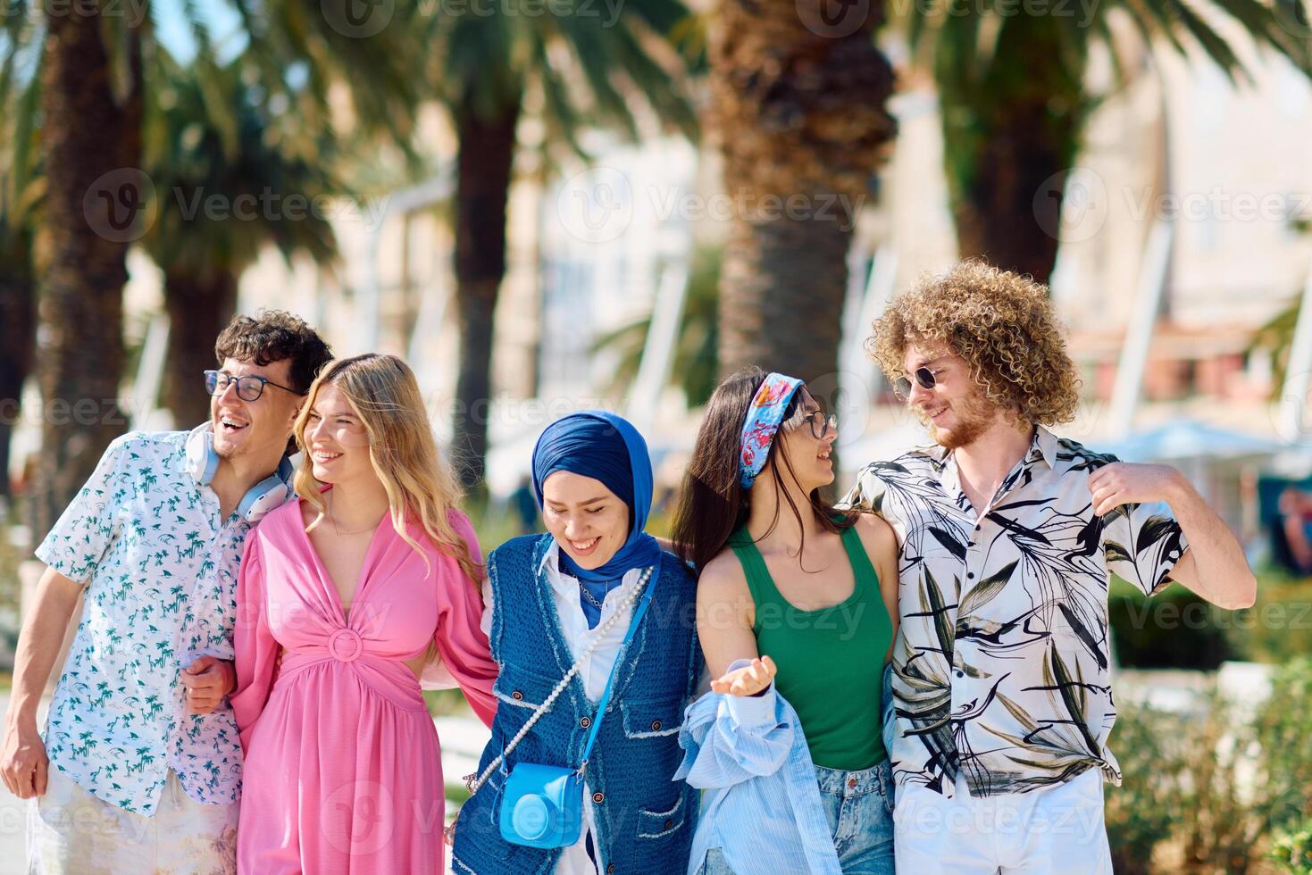 A diverse group of tourists, dressed in summer attire, strolls through the tourist city with wide smiles, enjoying their sightseeing adventure photo
