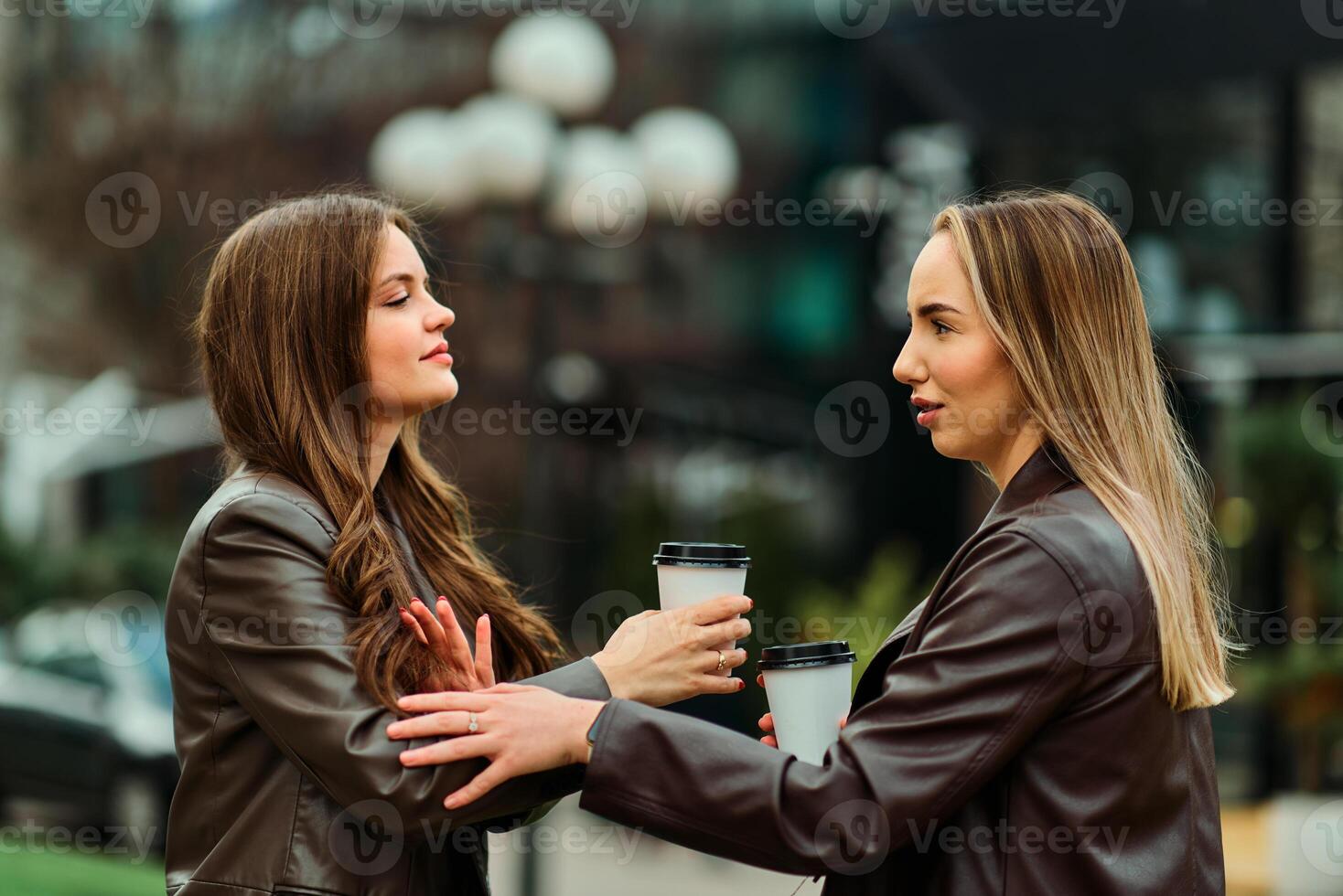 Two businesswomen enjoying a coffee break outside their office. photo