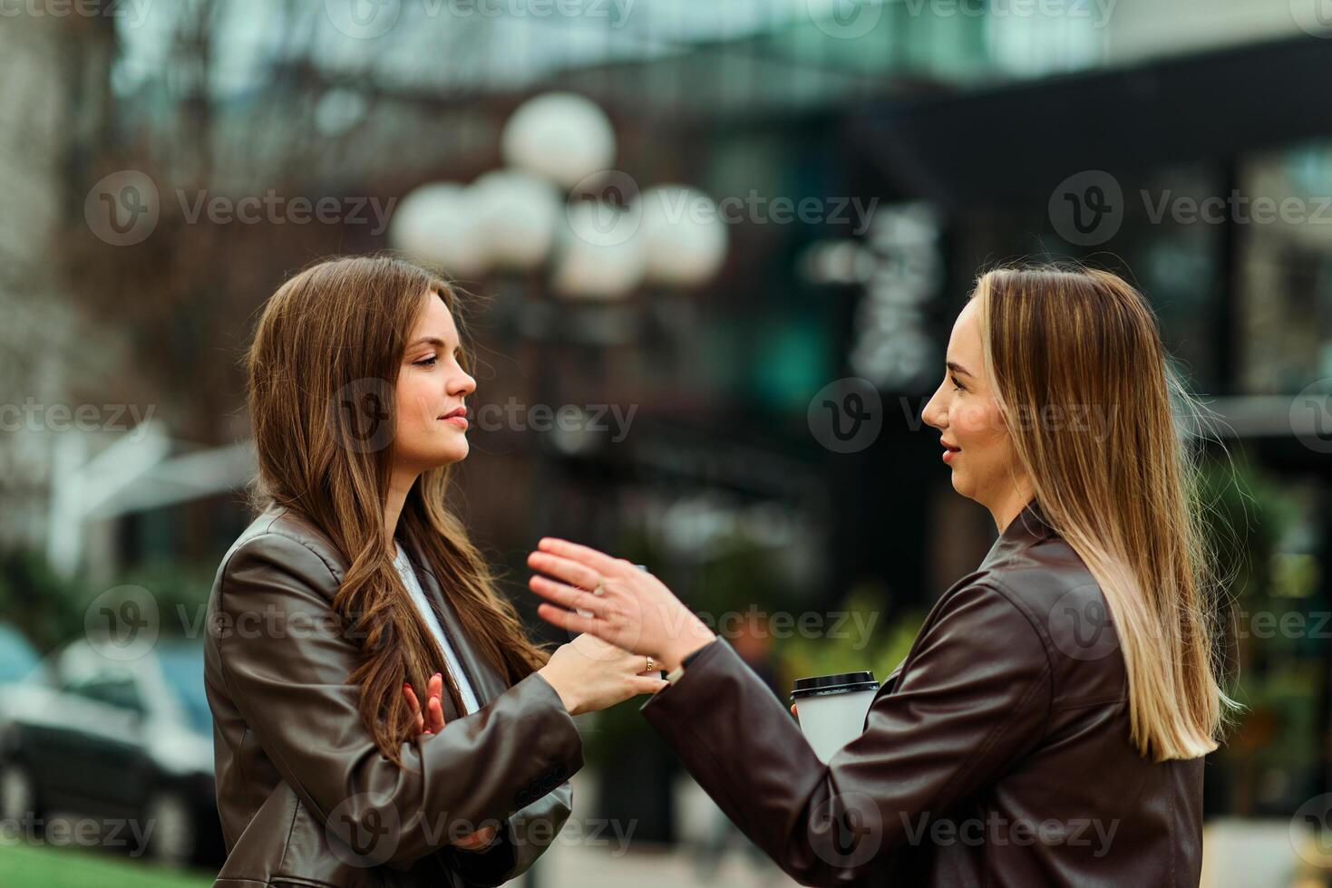 Two businesswomen enjoying a coffee break outside their office. photo