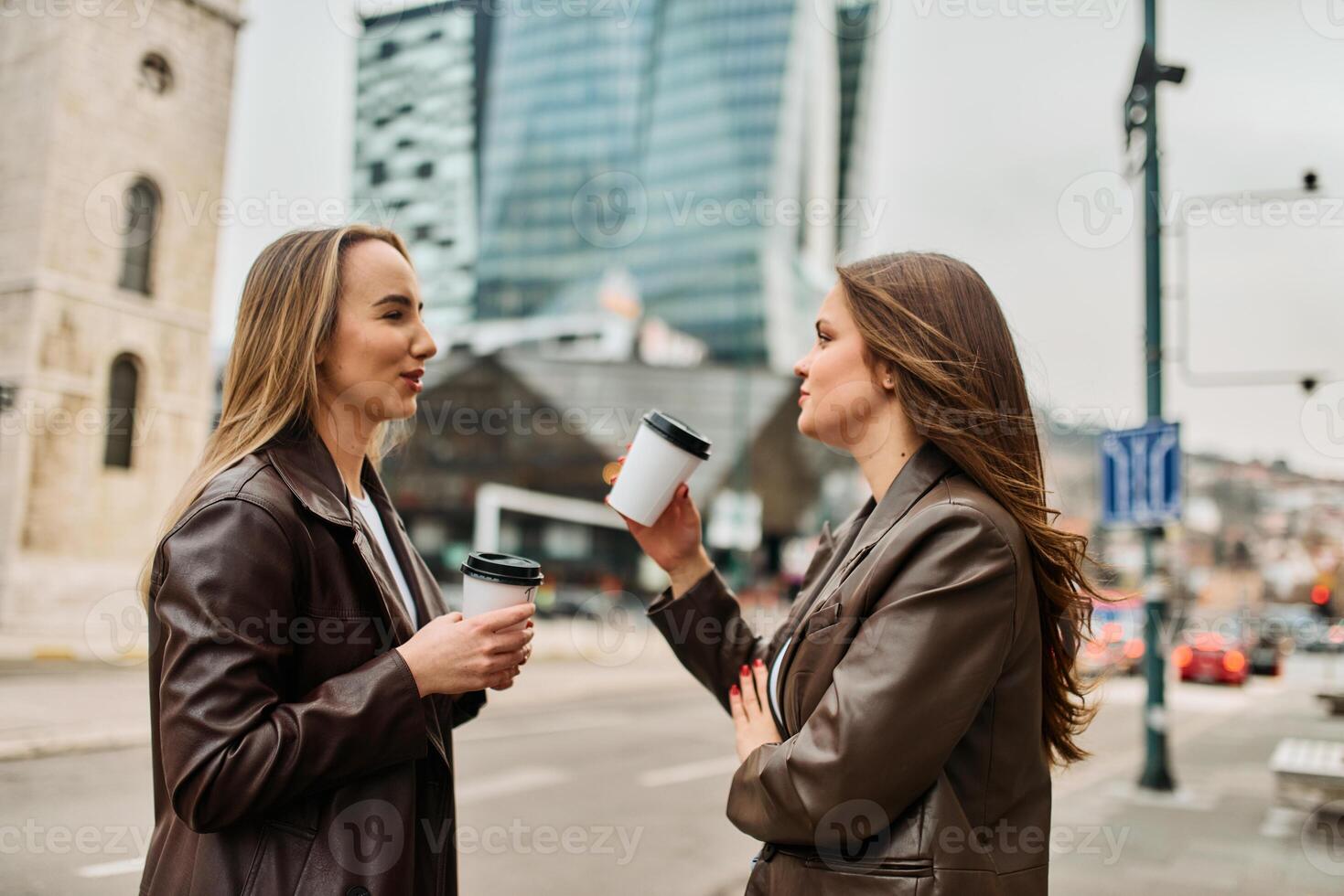Two businesswomen enjoying a coffee break outside their office. photo