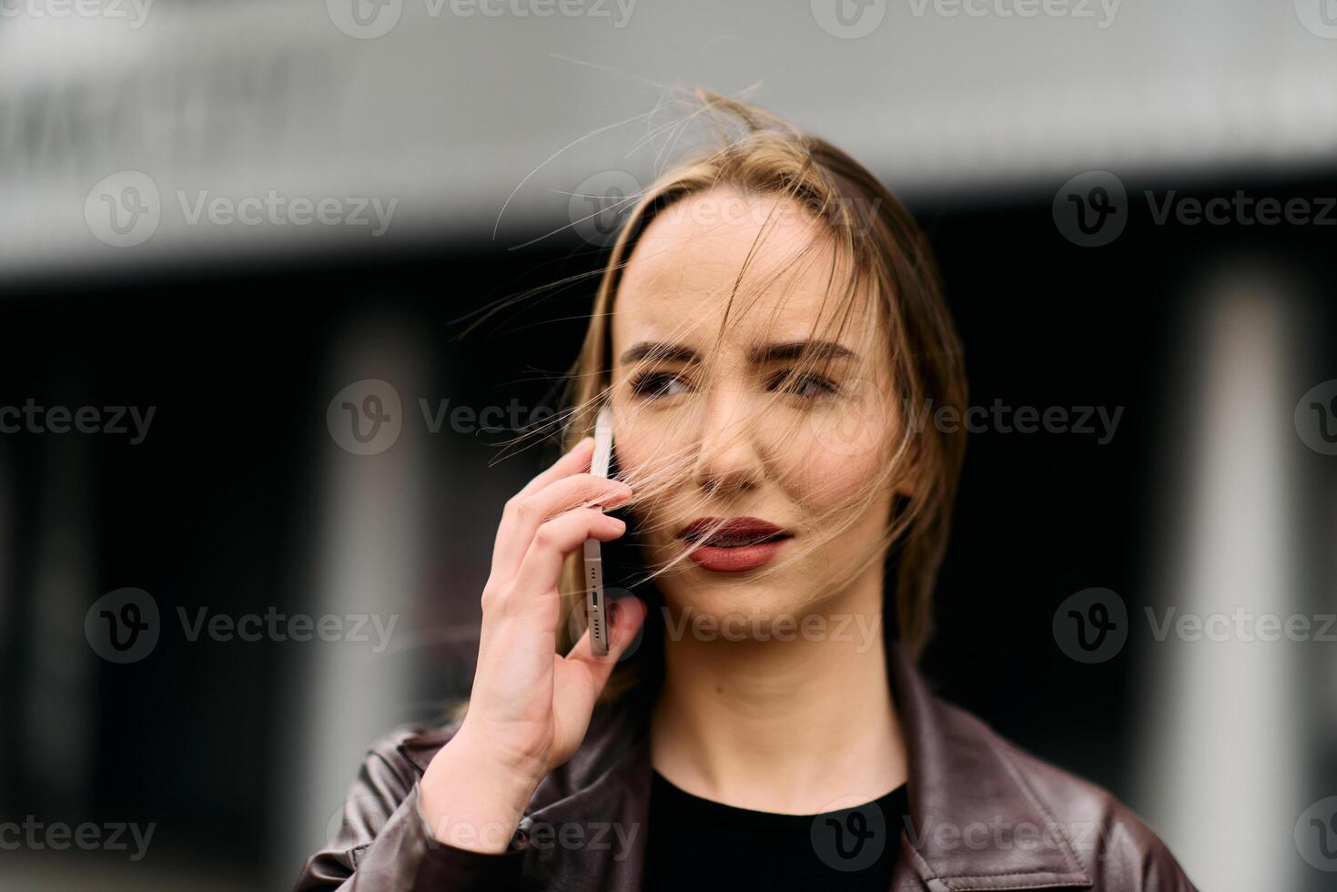 Business Woman With Phone Near Office. Portrait Of Beautiful Smiling Female In Fashion Office Clothes Talking On Phone While Standing Outdoors. Phone Communication. photo
