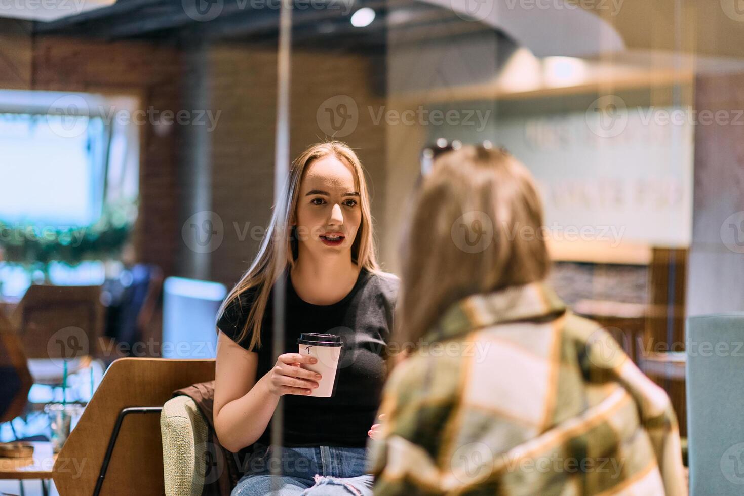 Catching Up and Caffeinating. Two Friends Unwind After a Long Day with Coffee and Conversation photo
